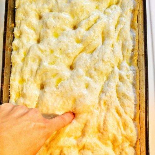 I am in love with this ridiculously easy focaccia bread recipe! This is a simple, homemade bread recipe that takes 5 minutes to mix together and is total comfort food. This is the bread recipe I make most often these days: it’s so easy and so good. Serve this focaccia with soup, as a side of pasta, or build a sandwich with it! | fast focaccia recipe | Italian focaccia recipe | best focaccia bread recipe | homemade focaccia bread