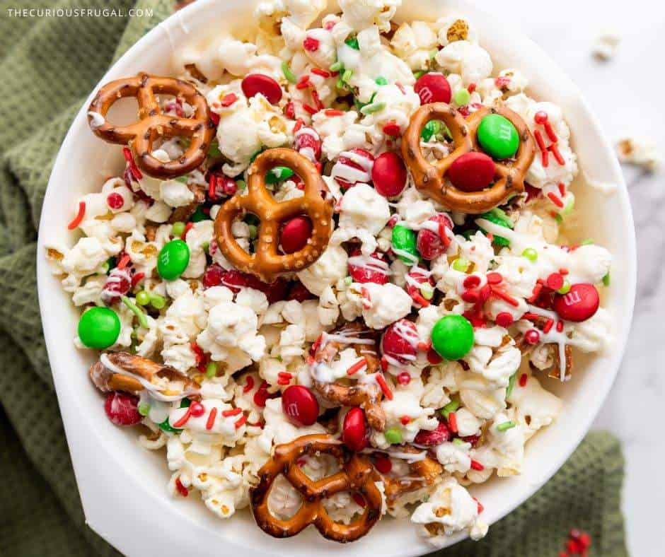 Make this easy Christmas popcorn for your next holiday movie night or party! This sweet and salty Christmas snack mix is loaded with chocolate, candy, and festive sprinkles — the perfect holiday treat for gifting or snacking. A quick Christmas recipe idea everyone will love!